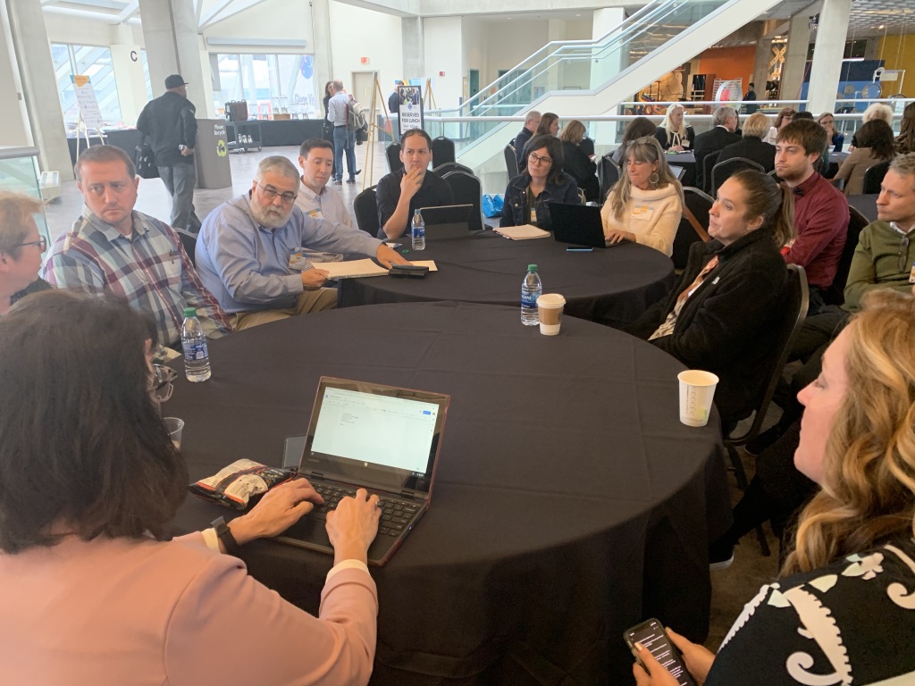 People gather at tabled during STEM Ecosystems Fall Convening, 2019 Cleveland, OH | BizzyB